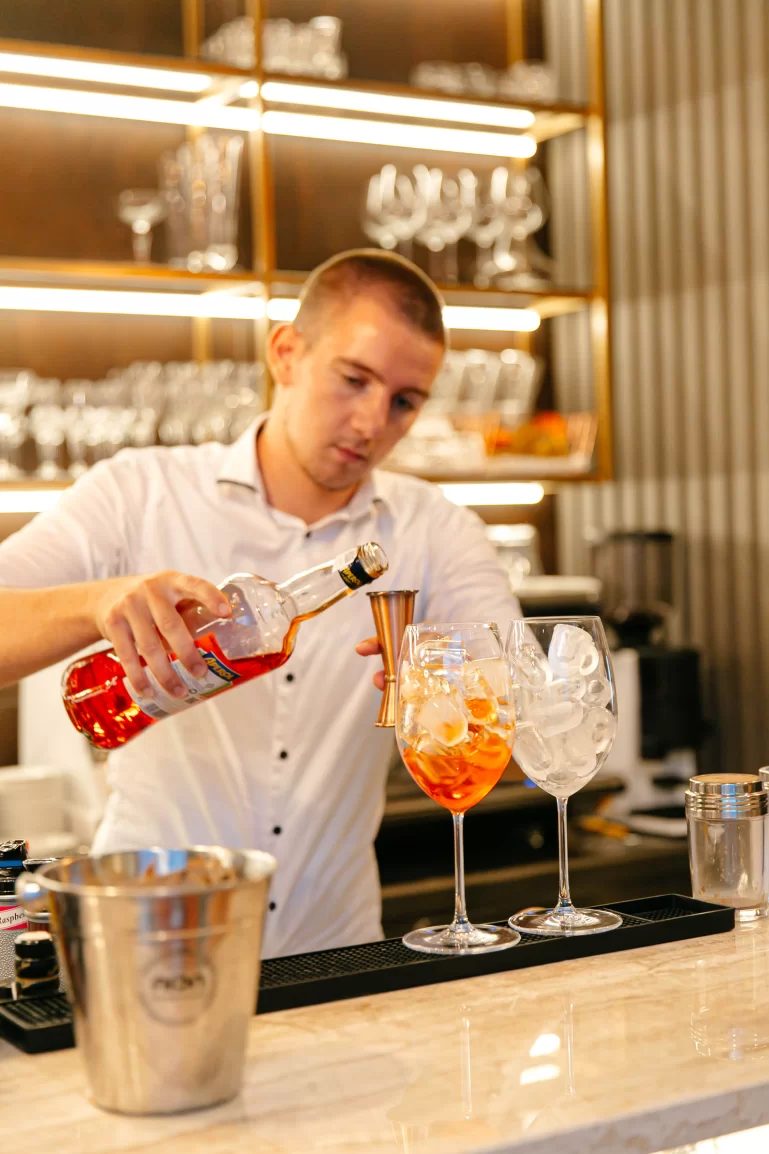 Croatian local mixologist at Medistone's bar prepairing an Aperol spritz